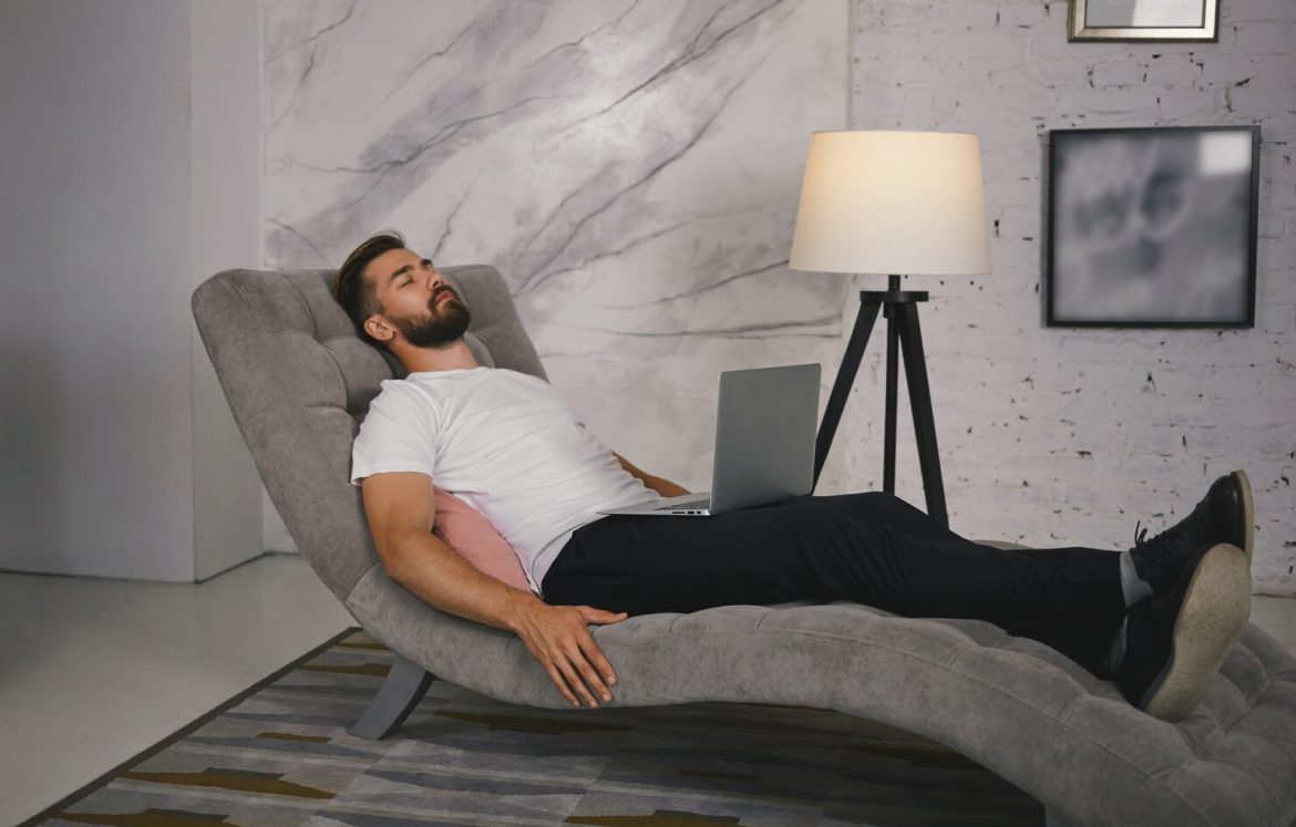 candid-shot-unshaven-young-male-shoes-lying-comfortably-gray-couch-with-portable-computer-his-lap-having-nap-meditating-keeping-his-eyes-closed-listening-relaxing-music_343059-798